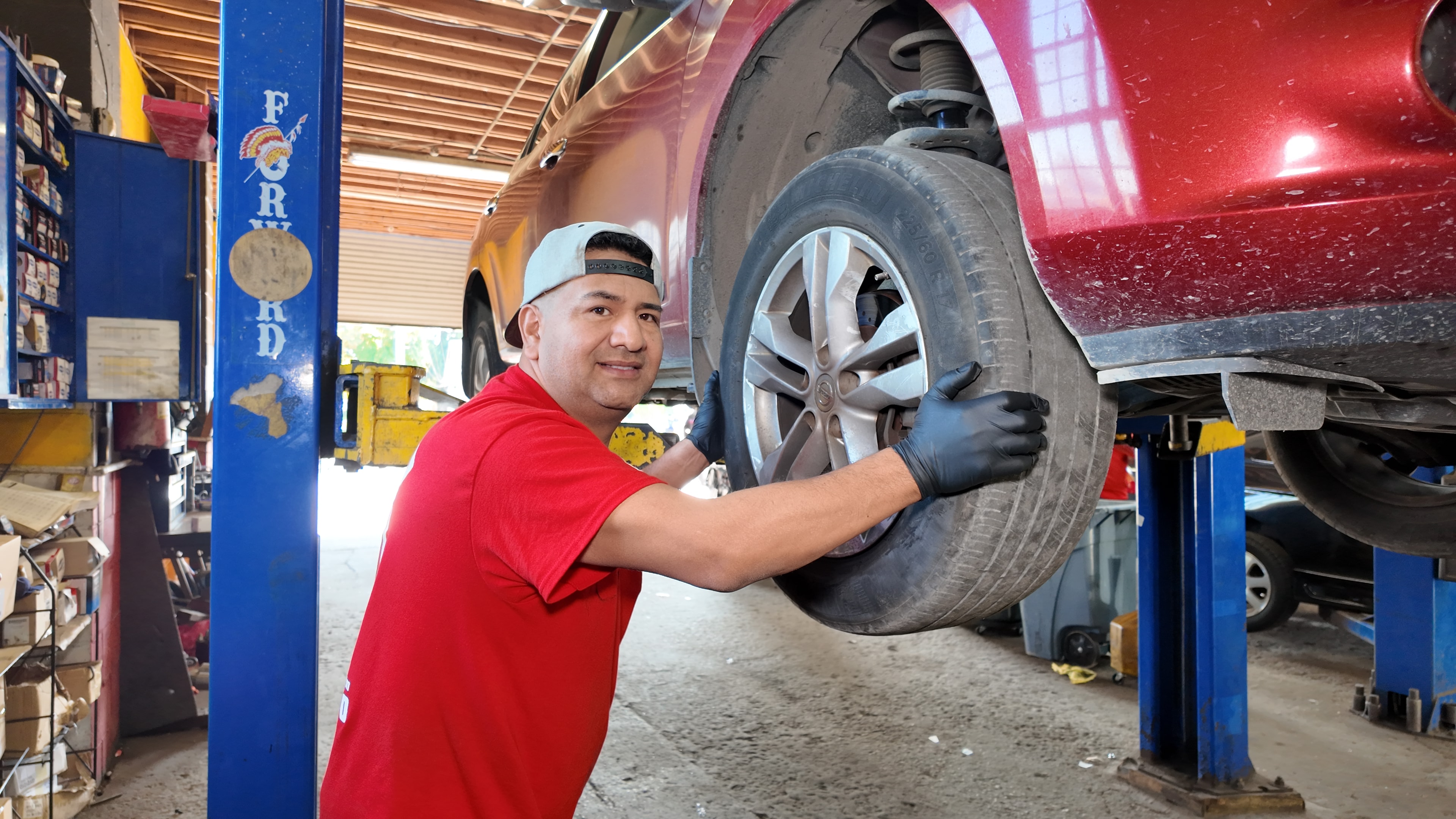 Technician setting wheel alignment equipment on a car
